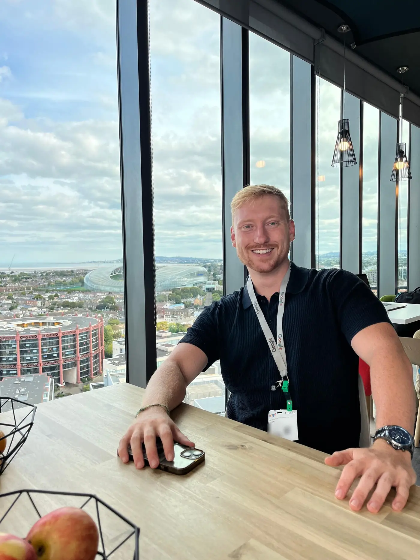 Maxim, who runs Adsvantage, at a window table in Google's Dublin office with the city and the Aviva Stadium behind him.